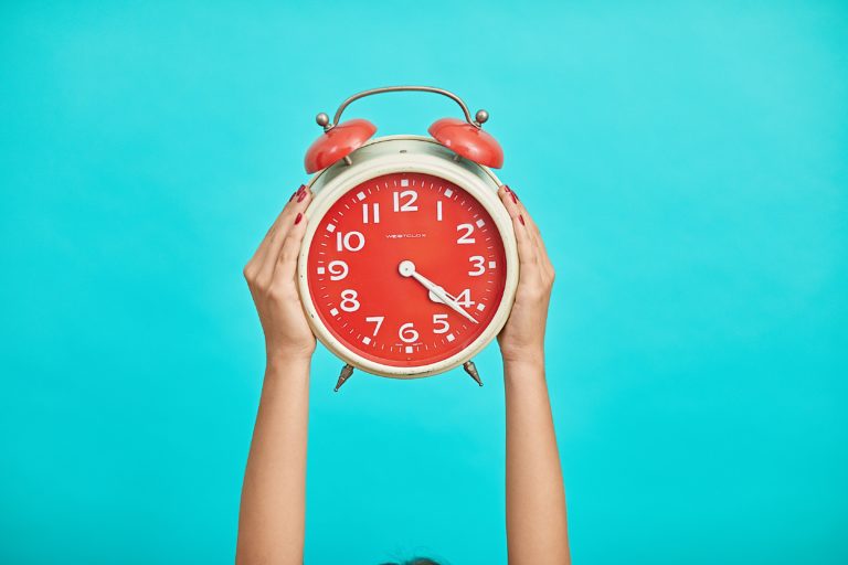 Hands holding alarm clock